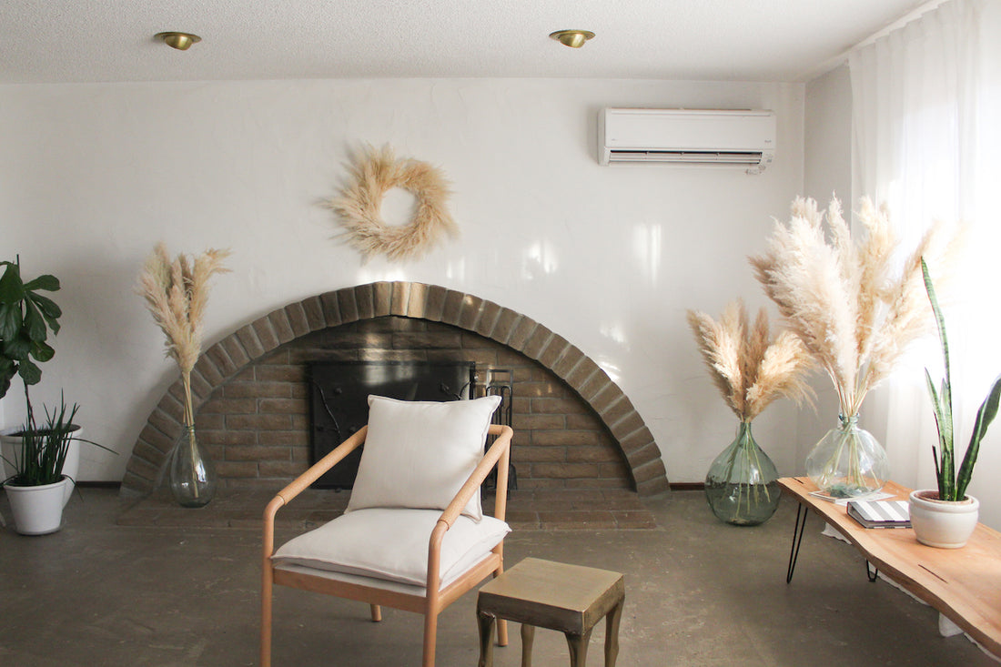 Minimalist-modern-living-room-with-brick-fireplace-pampas-grass-wreath-over-fireplace-dried-pampasgras-bouquet-in-green-vases-on-the-floor