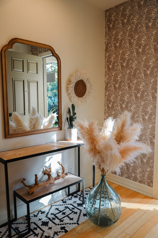 Dried pampas grass in terracota vase on top of entry way table